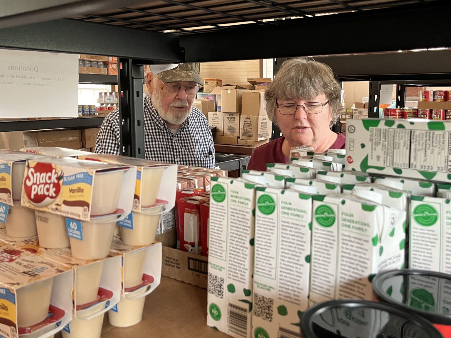 Volunteers sort shelves at a food bank.